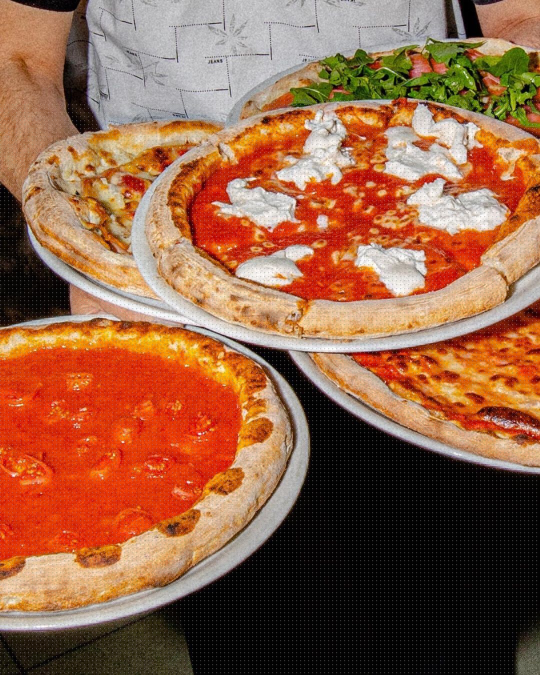Our pizzaiolo with pizzas from the wood-fired oven